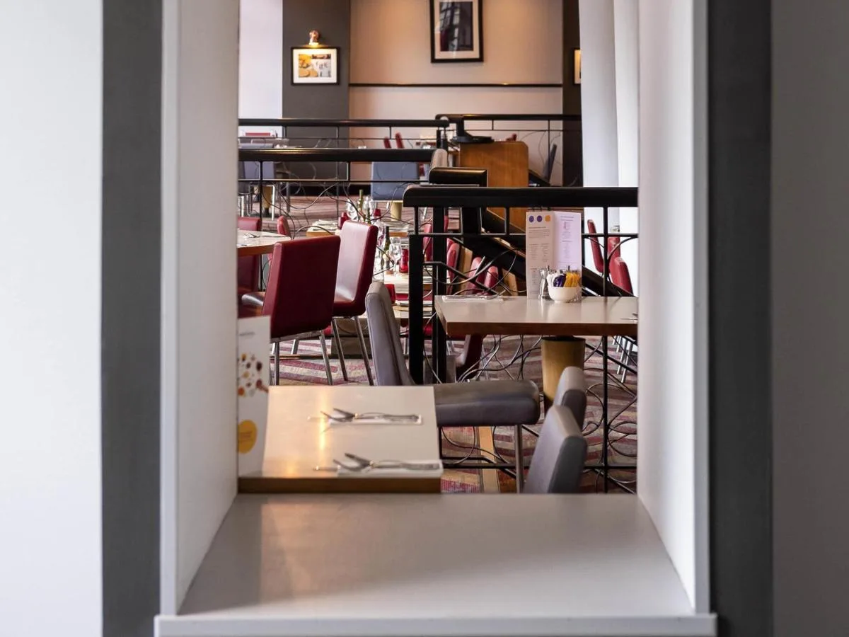 a view of a table and chairs in a room at Novotel Glasgow Centre in Glasgow