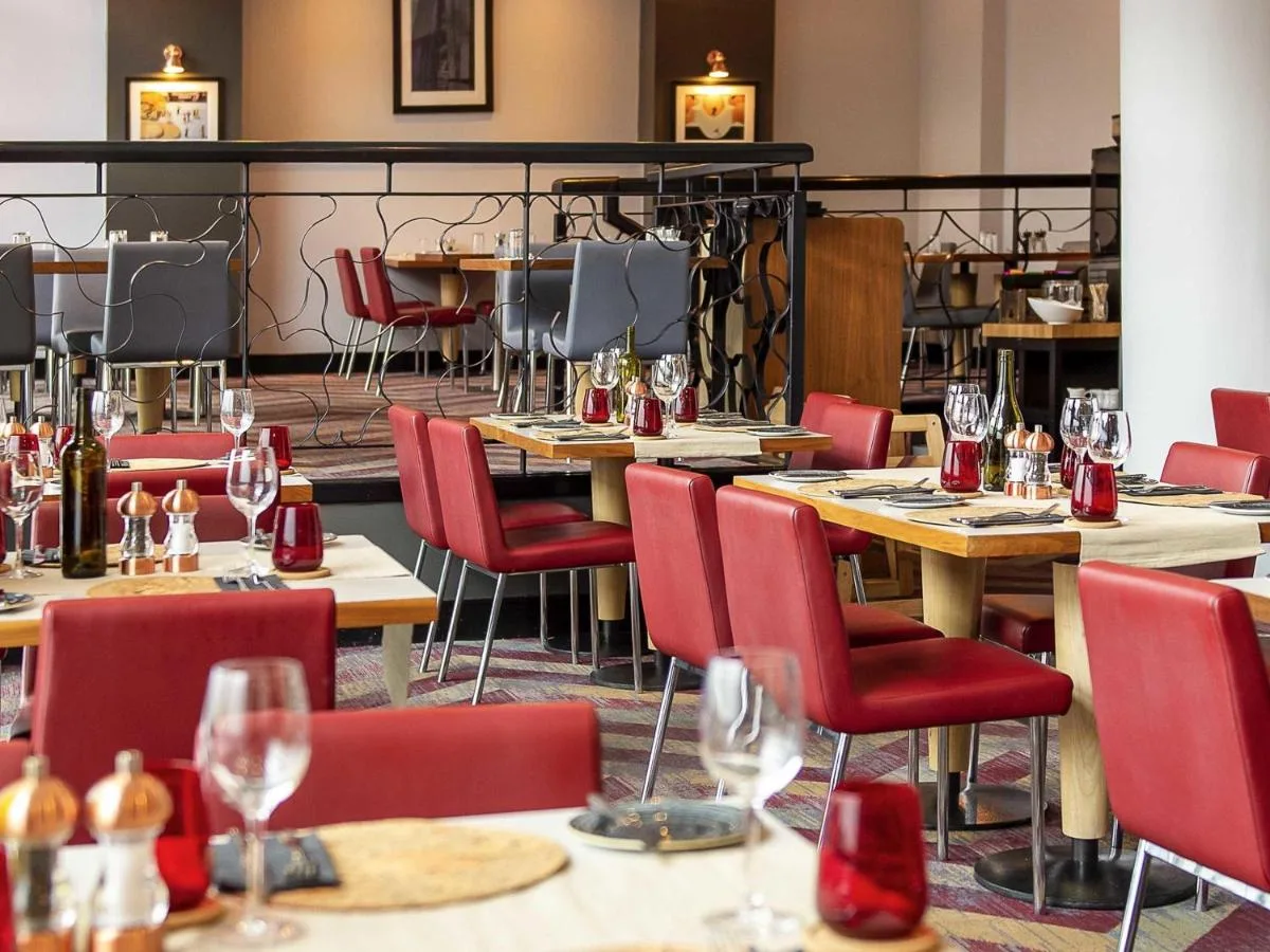 a restaurant with tables and chairs and wine glasses at Novotel Glasgow Centre in Glasgow